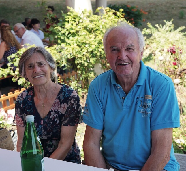 Ein älteres Ehepaar lächelt freundlich in die Kamera.  