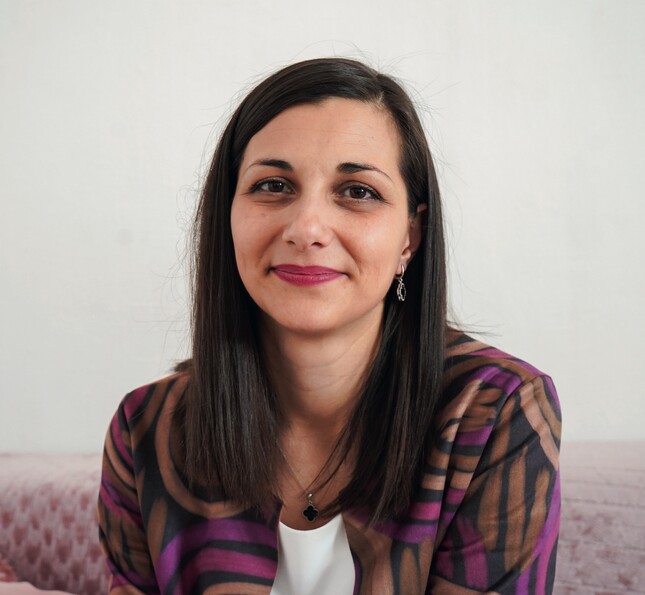 Eine Frau schaut lächelnd in die Kamera. 