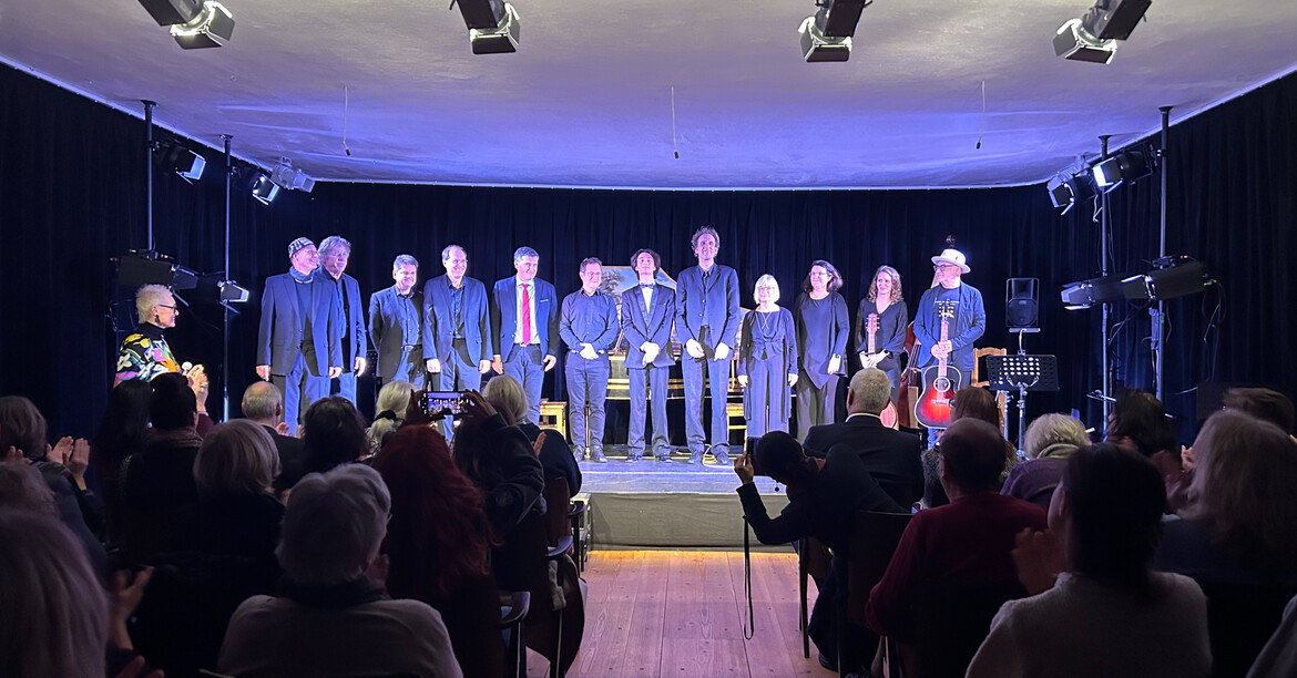 Die Musikerinnen und Musiker stehen nach dem Konzert auf der Bühne und Ihnen wird applaudiert.