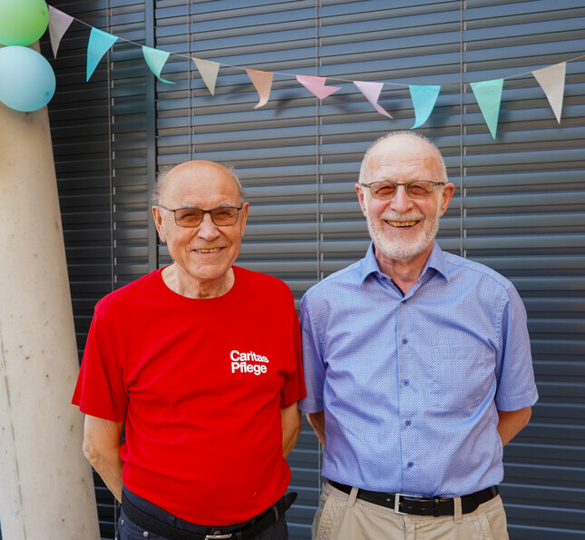 Zwei Bewohner lächeln freundlich in die Kamera. 